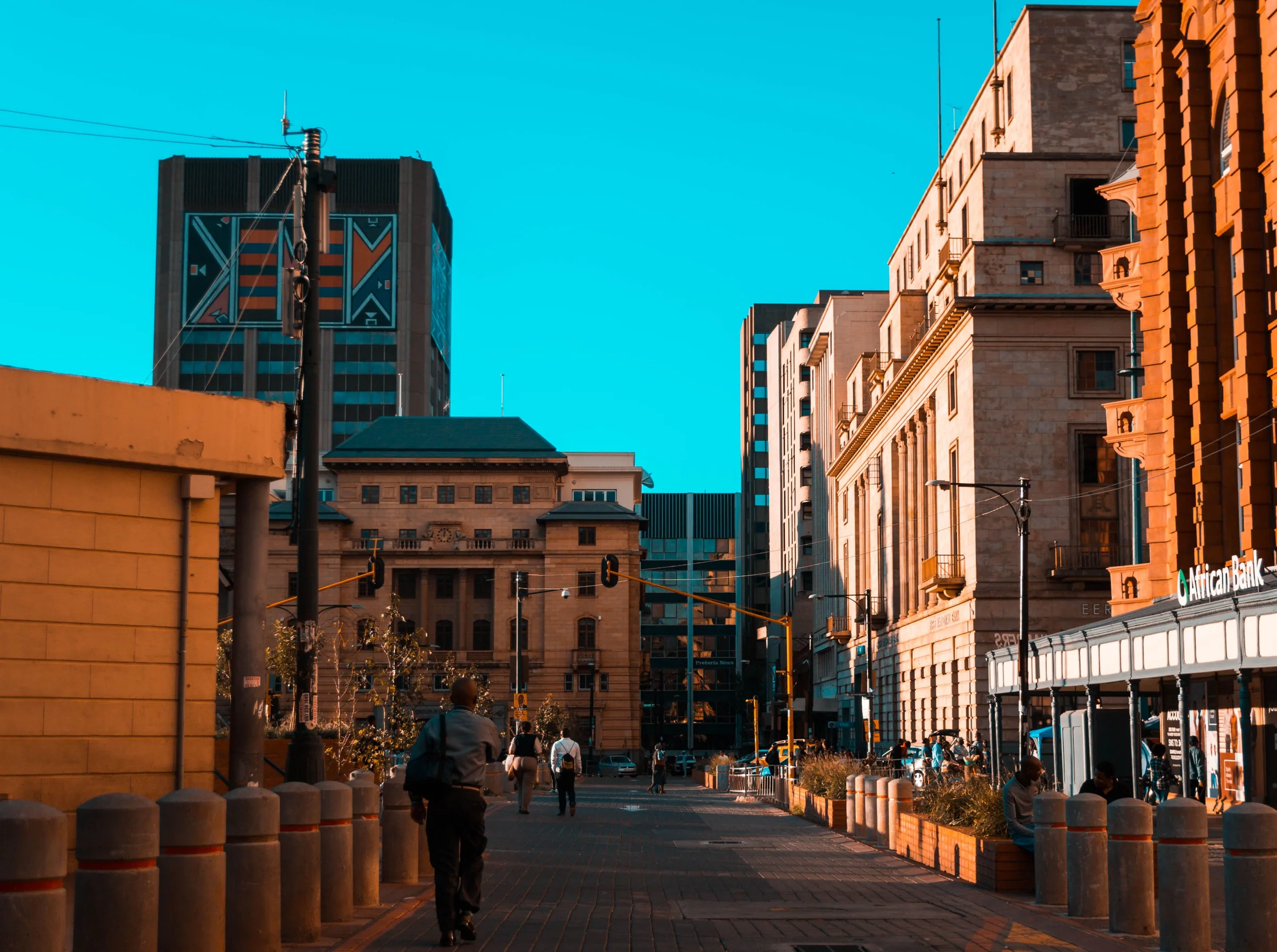 Pedestrians walking between historic and modern buildings in Johannesburg