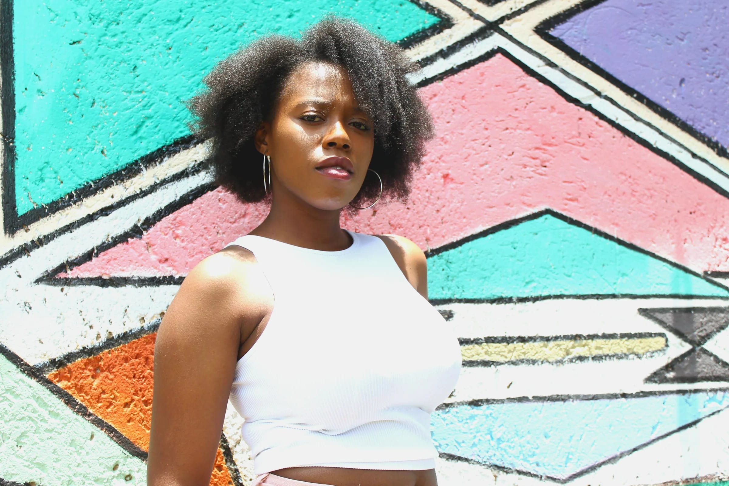 Young woman standing in front of a colourful Johannesburg mural